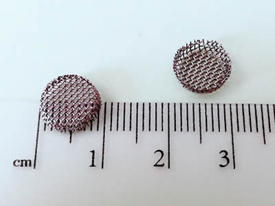 Zwei kleine schalenförmige Filter werden durch einen Machthaber gemessen und ihre Durchmesser sind ungefähr 9 Millimeter.